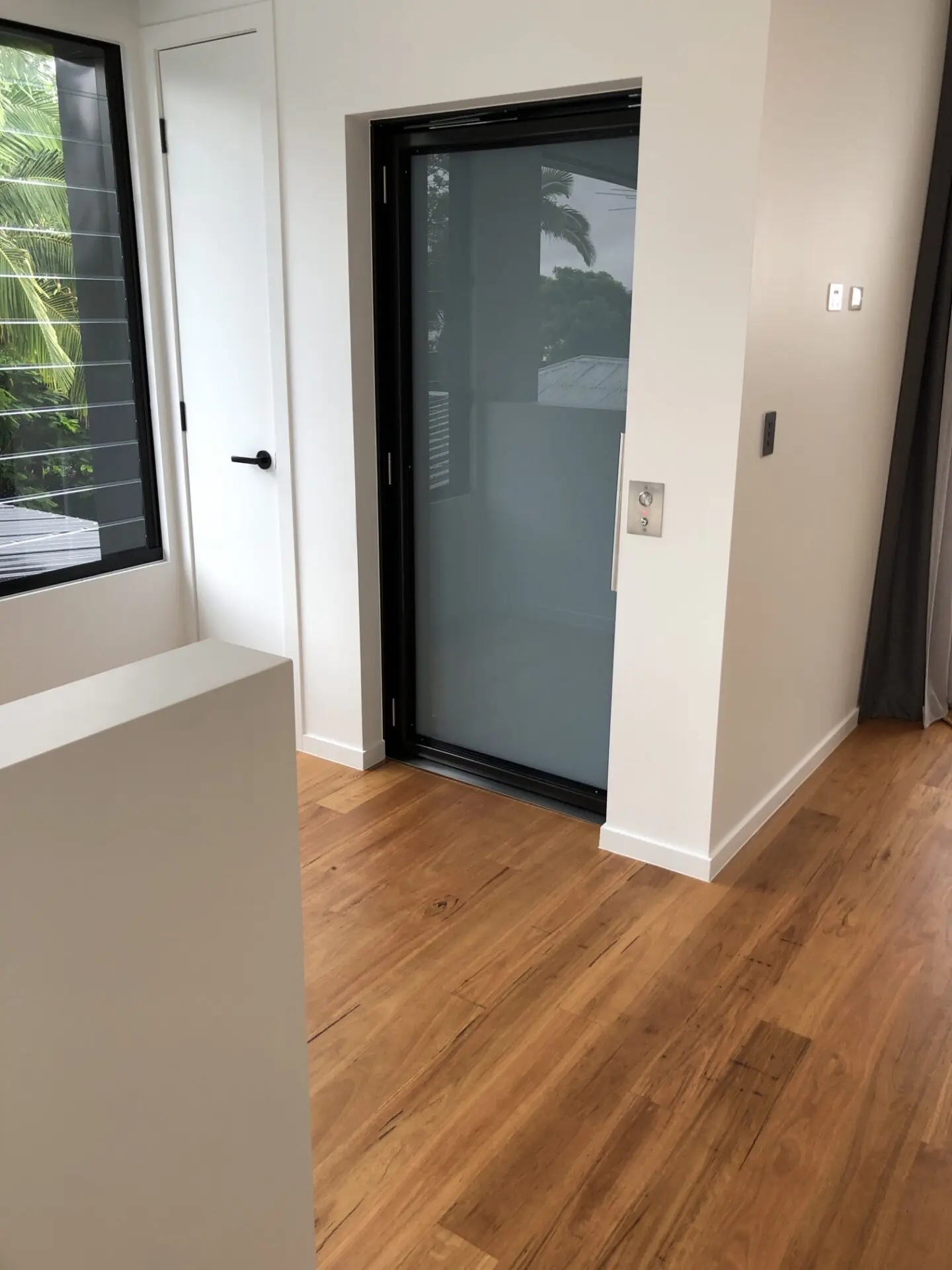 A platform lift landing door opening onto a timber floor